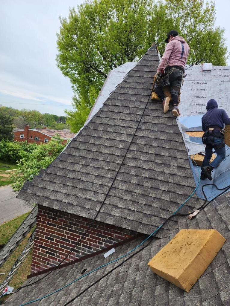 Gutter Buddy roofing crew installing new shingles on a Cincinnati Tudor-style home