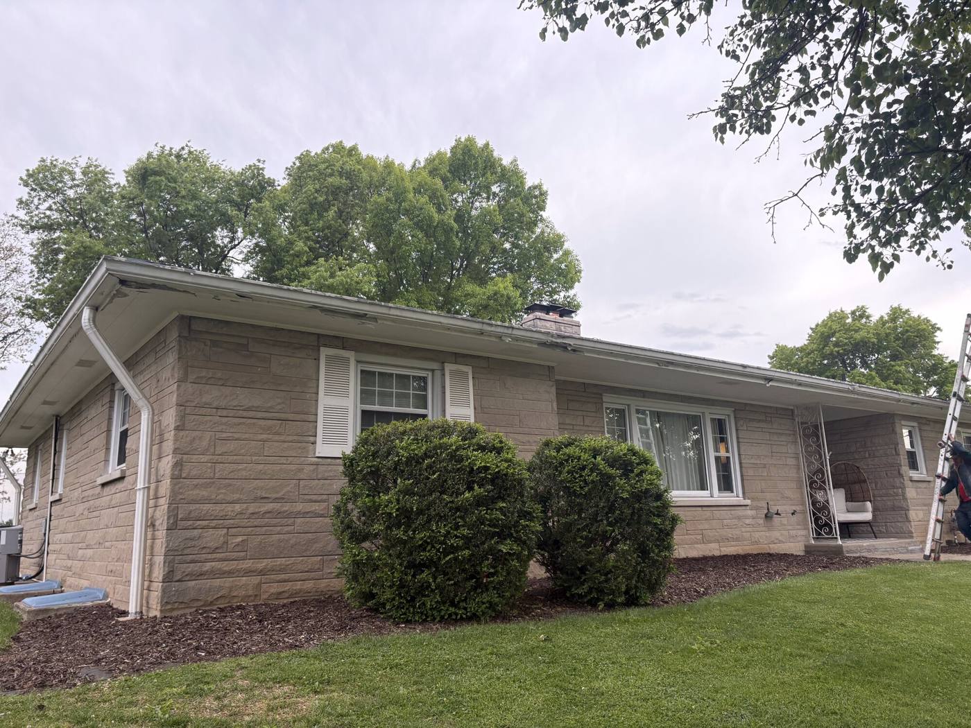Stone-veneer ranch home in Cincinnati with finished gutters and downspouts